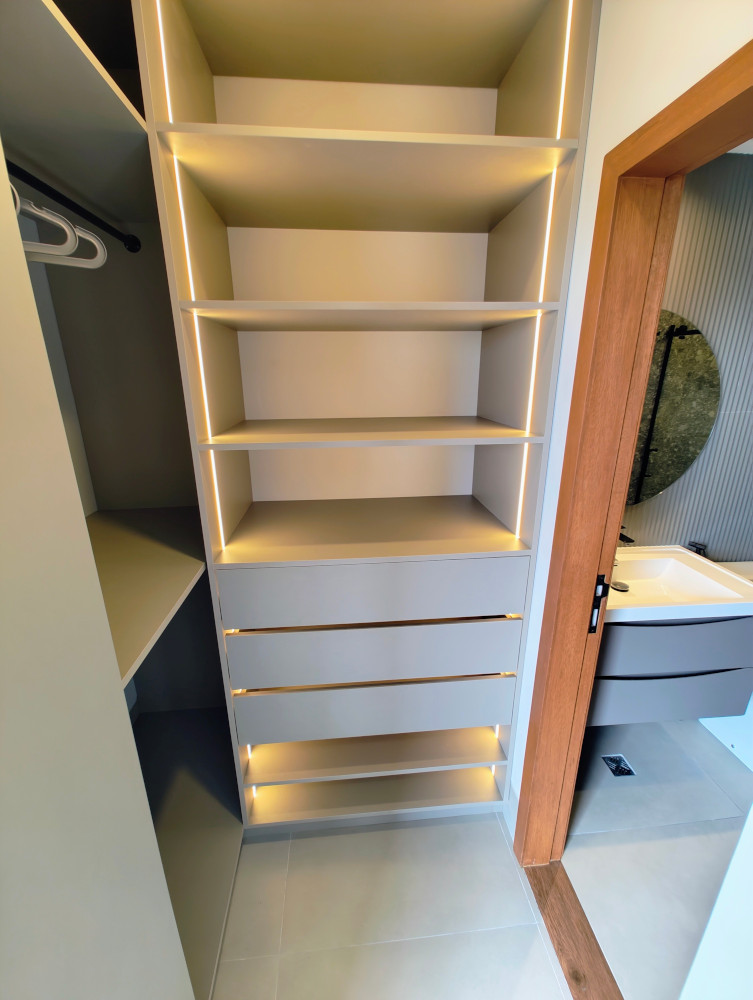 Built-in wardrobe with shelves, drawers, and vertical LED lighting